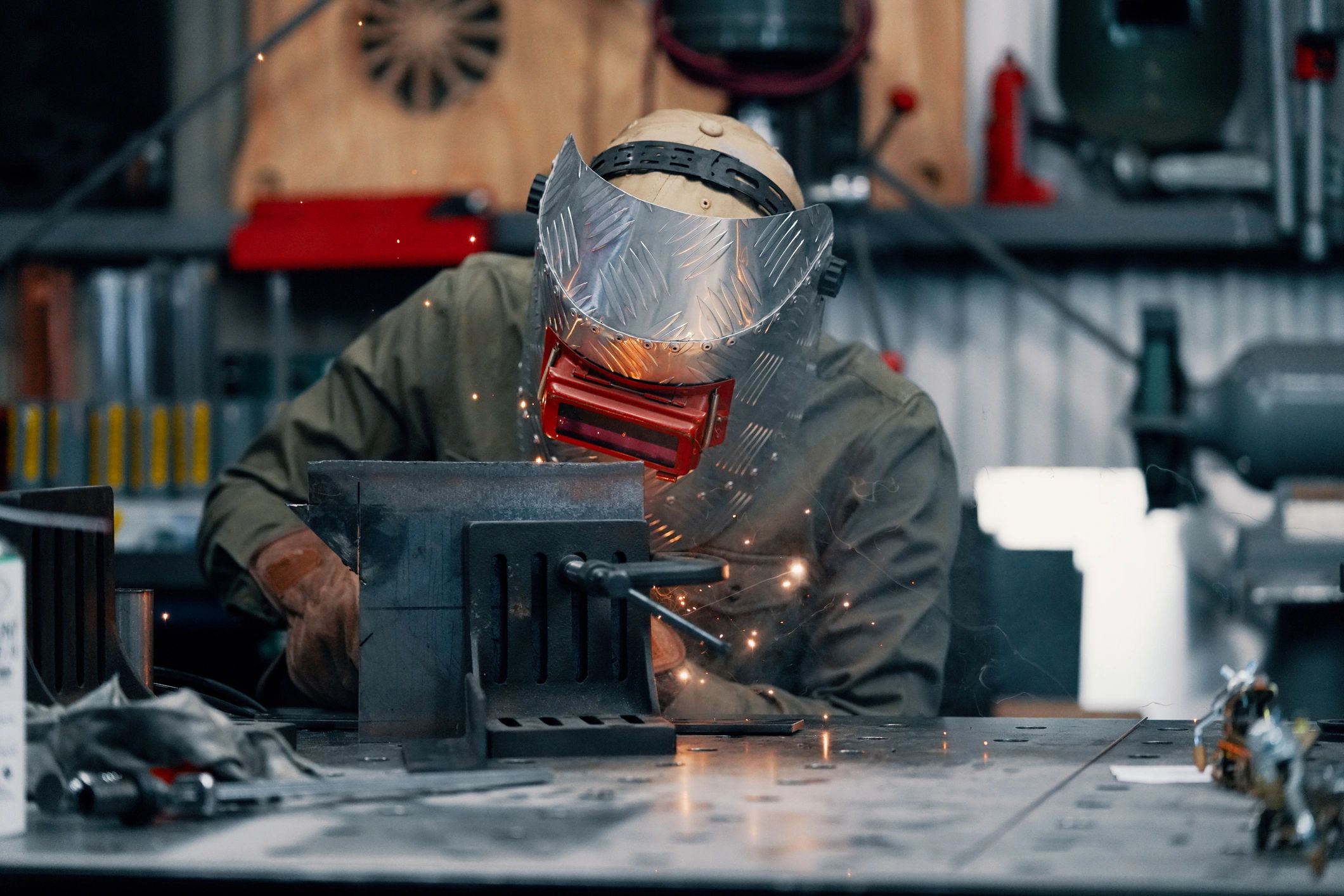 Welder fabricating metal components in an industrial shop