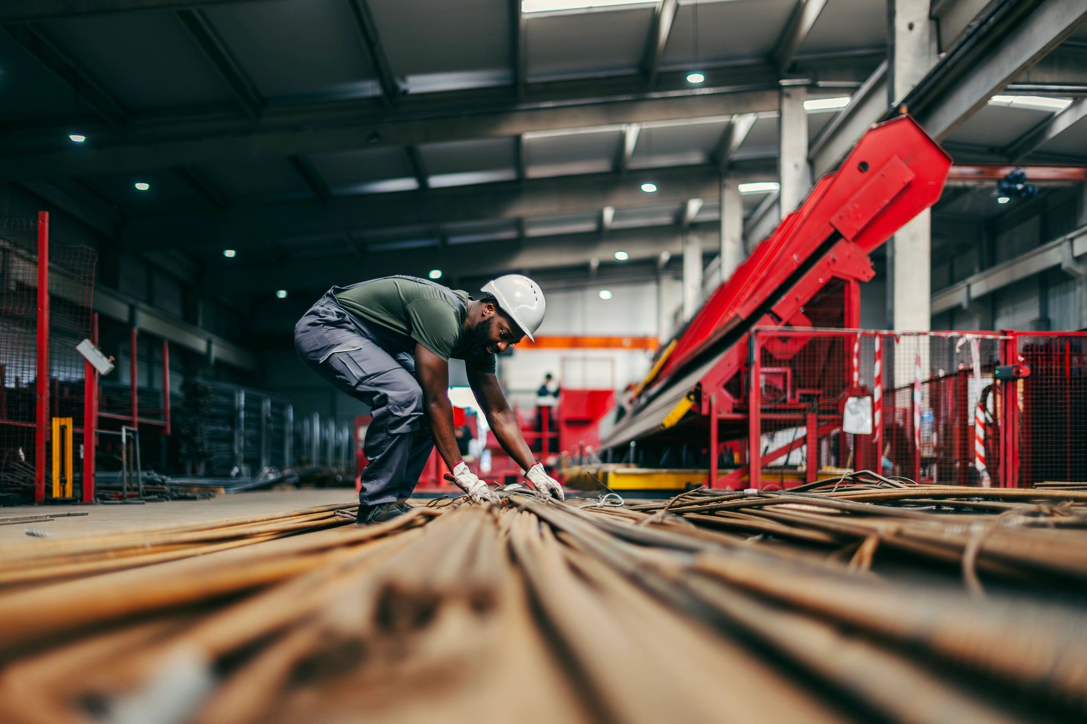 Industrial worker handling metal components in a factory